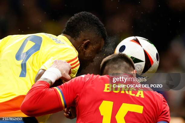 Colombia's forward Jhon Cordoba heads the ball to scores his team's first goal next to Romania's defender Andrei Burca during the international...