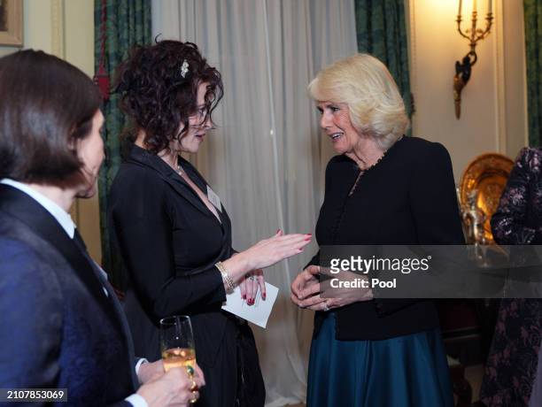 Queen Camilla speaks to Donna Tartt and Helena Bonham Carter during a reception to mark the findings of a new research study commissioned by The...
