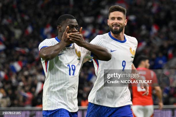France's midfielder Youssouf Fofana celebrates scoring his team's first goal with France's forward Olivier Giroud during the friendly football match...