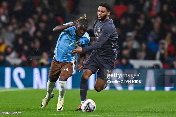 Belgium's midfielder Jeremy Doku vies for the ball with England's defender Joe Gomez during the International friendly football match between England...