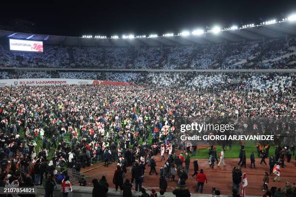Georgia fans invade the pitch after their team won the UEFA EURO 2024 qualifying play-off final football match between Georgia and Greece in Tbilisi...