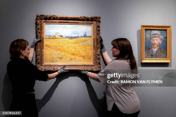 Exhibition staff members hang a painting by Vincent van Gogh in a room for a long-term loan at the Rijksmuseum, in Amsterdam, on March 26, 2024. /...