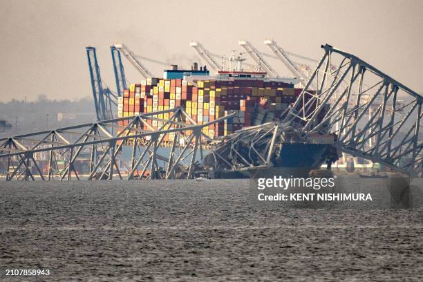 Part of the steel frame of the Francis Scott Key Bridge sits on top of the container ship Dali after the bridge collapsed in Baltimore, Maryland, on...