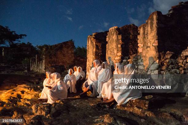 Catholic women dressed in white sheets take part in the Terno das Almas procession in Igatu on the Chapada Diamantina National Park, Bahia State,...