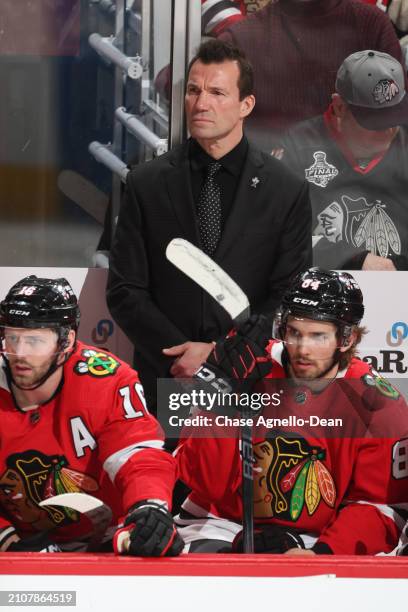 Head coach Luke Richardson of the Chicago Blackhawks stands behind Jason Dickinson and Landon Slaggert in the third period against the Calgary Flames...