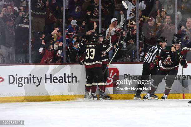 Josh Doan of the Arizona Coyotes celebrates with teammate Travis Dermott after scoring his first career NHL goal against the Columbus Blue Jackets...