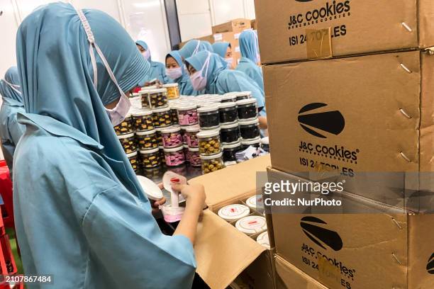 Employees are putting cookies into jars at the J&amp;C Cookies factory in Bandung, Indonesia, on March 27, 2024. The cookie manufacturer, J&amp;C...