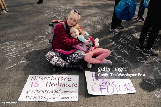 Abortion rights advocate Laura Klime Coates of Baltimore embraces her daughter, Charlize as they pose for a portrait with her sign outside the...