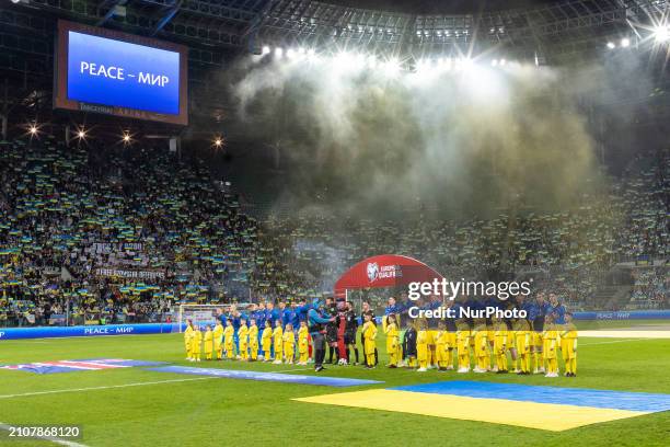 The Icelandic and Ukrainian teams are standing during the playing of the national anthems before the UEFA EURO 2024 Play-Offs final match between...