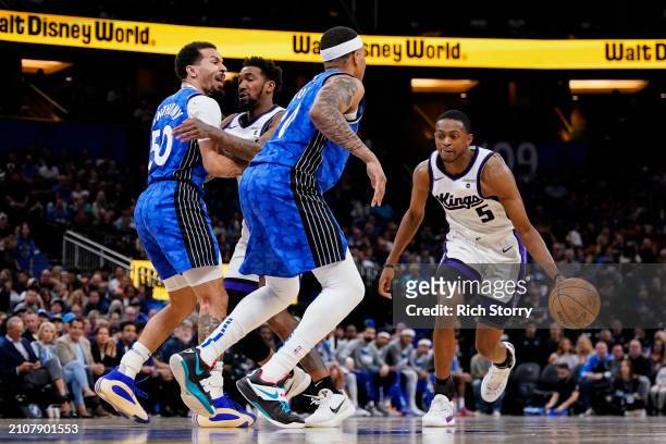De'Aaron Fox of the Sacramento Kings dribbles the ball against Markelle Fultz of the Orlando Magic during the second quarter at Kia Center on March...
