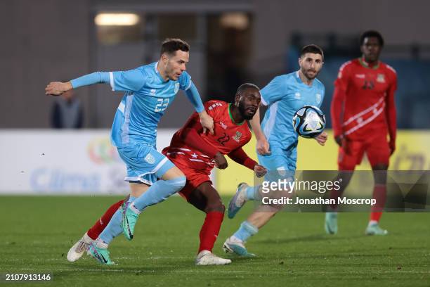 Alessandro Golinucci of San Marino and Mervin Lewis of St. Kitts and Nevis look on as Omari Sterling-James of St. Kitts and Nevis passes the ball...