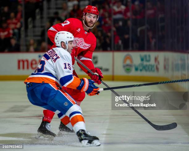 Michael Rasmussen of the Detroit Red Wings shoots the puck past Cal Clutterbuck of the New York Islanders during the first period at Little Caesars...