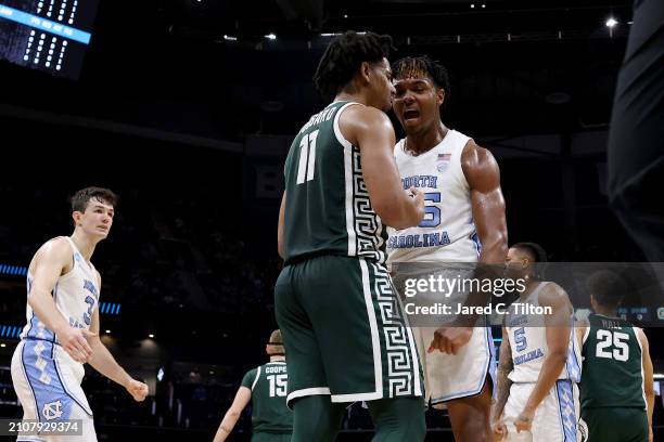 Harrison Ingram of the North Carolina Tar Heels celebrates a play as A.J. Hoggard of the Michigan State Spartans reacts during the first half in the...