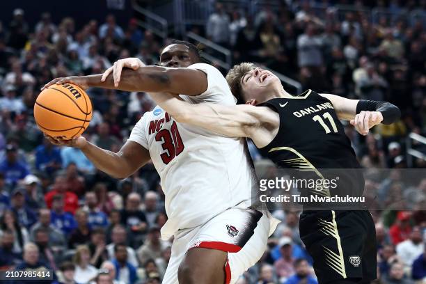 Burns Jr. #30 of the North Carolina State Wolfpack battles Blake Lampman of the Oakland Golden Grizzlies for a rebound during the second half of a...