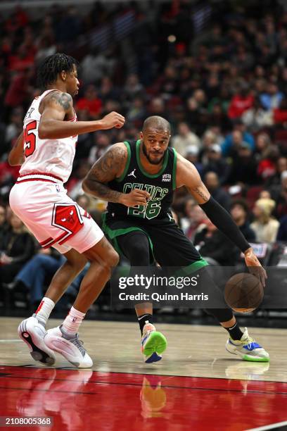 Xavier Tillman of the Boston Celtics handles the basketball in the first half against Dalen Terry of the Chicago Bulls at the United Center on March...