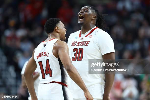 Casey Morsell and DJ Burns Jr. #30 of the North Carolina State Wolfpack react during overtime of a game against the Oakland Golden Grizzlies in the...