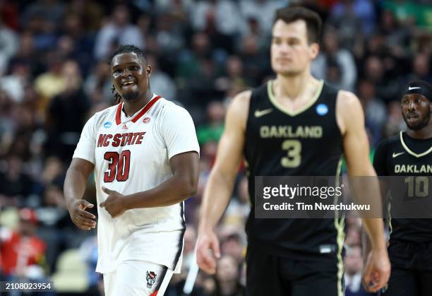 Burns Jr. #30 of the North Carolina State Wolfpack reacts as Jack Gohlke of the Oakland Golden Grizzlies looks on during overtime of a game in the...