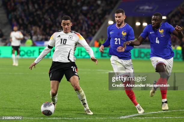 Jamal Musiala of Germany battles for the ball with Lucas Hernandez of France and his team mate Dayot Upamecano during the international friendly...