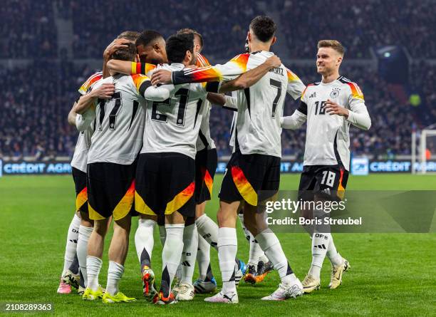 Florian Wirtz of Germany celebrates with teammates after scoring his team's first goal during the international friendly match between France and...