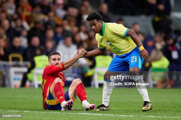 Endrick Felipe Moreira de Sousa, known as Endrick of Brazil helps Daniel Carvajal of Spain to stand up during the international friendly match...