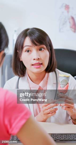 asian doctor thyroid model explain - hypothyroidism stock pictures, royalty-free photos & images