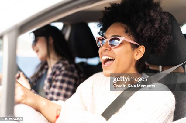 happy friends singing during road trip - cantare foto e immagini stock