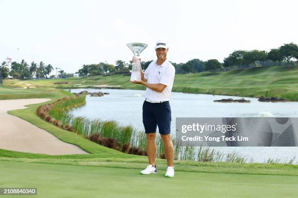 Jesper Svensson of Sweden poses with the trophy after victory during Day Four of the Porsche Singapore Classic at Laguna National Golf Resort Club on...