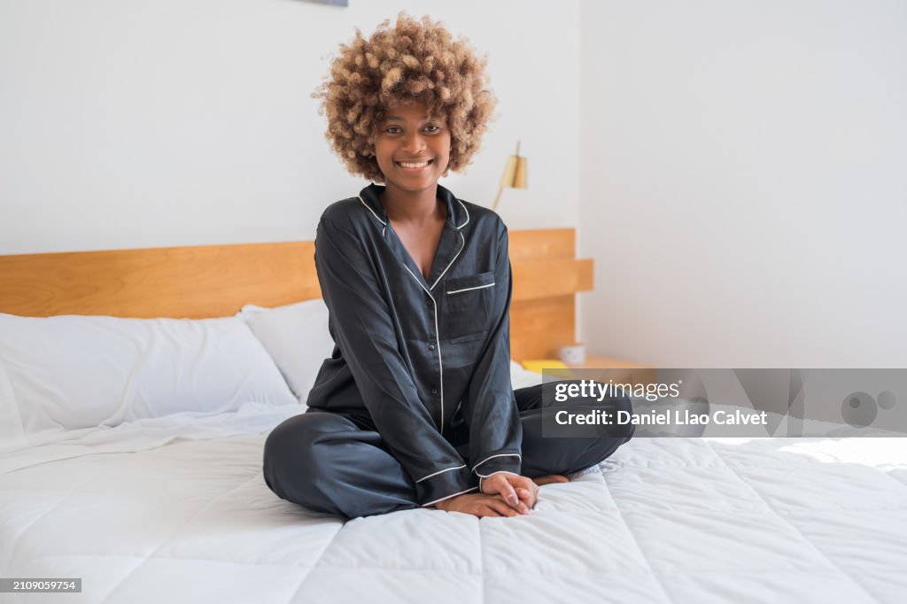 Mixed race woman sitting on a bed