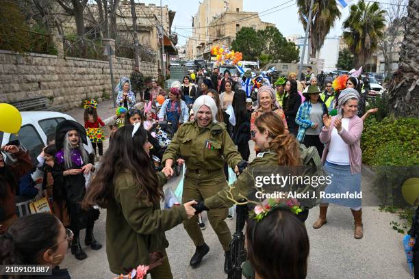 Jewish settlers wearing costumes celebrate Purim as Israeli security forces secure the celebrations on March 24, 2024 in Hebron, West Bank. This year...