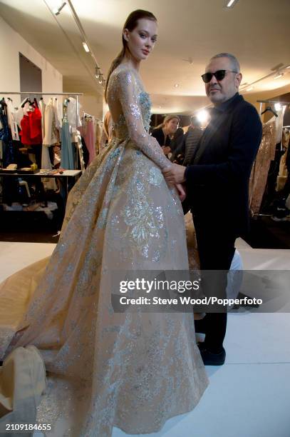 Designer Elie Saab and model Tanya Katysheva backstage at his Couture show during Paris Fashion Week Spring/Summer 2019, her long sleeved wedding...