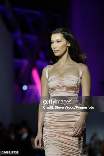 Bella Hadid walks the runway at Fashion for Relief 2018 during the 71st annual Cannes Film Festival, she wears a fitted strappy dress in dusty pink...