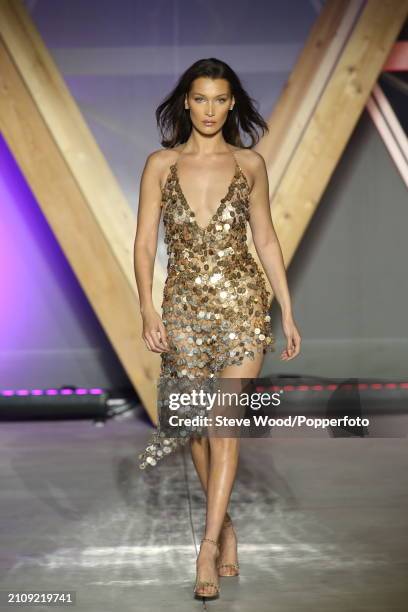 Bella Hadid walks the runway at Fashion for Relief 2018 during the 71st annual Cannes Film Festival, she wears a bronze sequinned dress with a low...