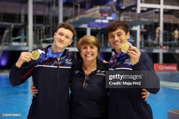 Gold medalists Noah Williams and Thomas Daley of Team Great Britain pose for a photo with their medals and Coach Jane Figueiredo after the medal...