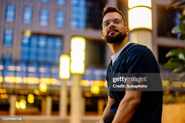 male nurse waiting outdoors. - city life authentic stock pictures, royalty-free photos & images