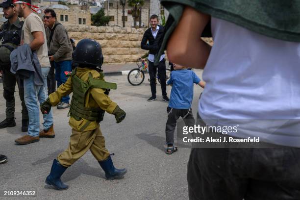Jewish settlers wearing costumes celebrate Purim during the parade as Israeli security forces secure the celebrations on March 24, 2024 in Hebron,...