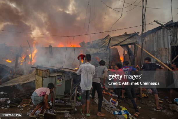 Men attempt to douse a fire which engulfed a slum dwelling on March 24, 2024 in the Banani neighbourhood of Dhaka, Bangladesh.
