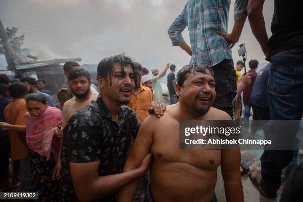 Men cry as their house burns down in a fire which engulfed a slum dwelling on March 24, 2024 in the Banani neighbourhood of Dhaka, Bangladesh.