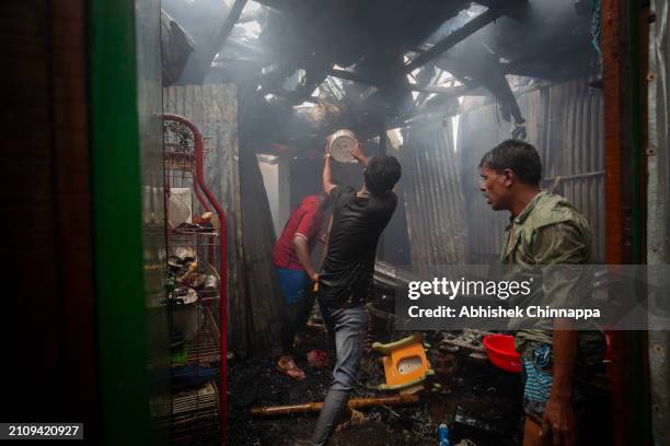 Men attempt to douse a fire which engulfed a slum dwelling on March 24, 2024 in the Banani neighbourhood of Dhaka, Bangladesh.