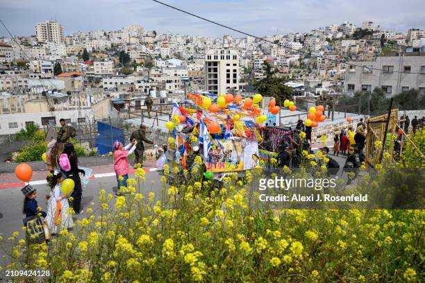 Jewish settlers wearing costumes celebrate Purim as Israeli security forces secure the celebrations March 24, 2024 in Hebron, West Bank. Unlike...