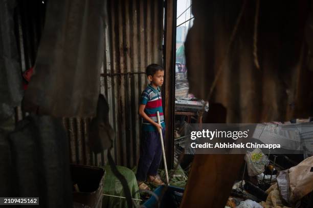 Young boy stands in a burnt house after a fire engulfed a slum dwelling on March 24, 2024 in the Banani neighbourhood of Dhaka, Bangladesh.