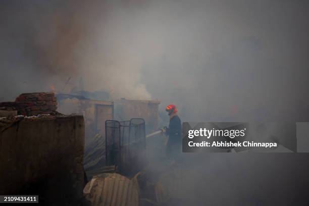 Firefighters attempt to douse a fire which engulfed a slum dwelling on March 24, 2024 in the Banani neighbourhood of Dhaka, Bangladesh.