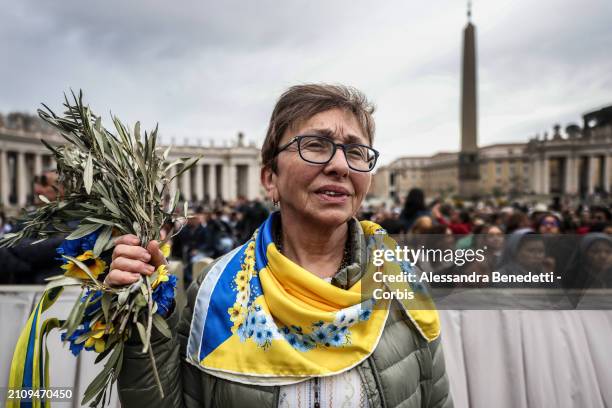 Catholic faithful from Ukraine attend the Palm Sunday Mass, presided by Pope Francis in St. Peter's Square, on March 24, 2024 in Vatican City,...