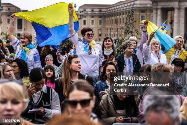 Catholic faithful from Ukraine attend the Palm Sunday Mass, presided by Pope Francis in St. Peter's Square, on March 24, 2024 in Vatican City,...