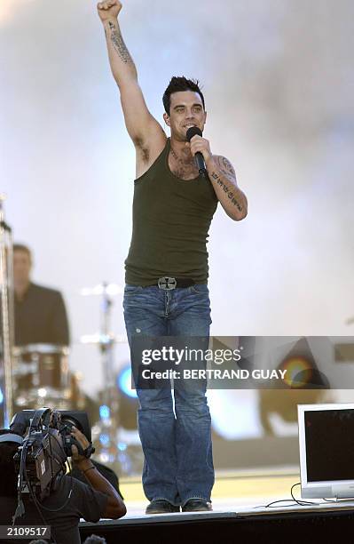 British singer Robbie Williams performs late 21 June 2003 at the base of the Eiffel tower in Paris for a free concert for the Fete de la musique. AFP...