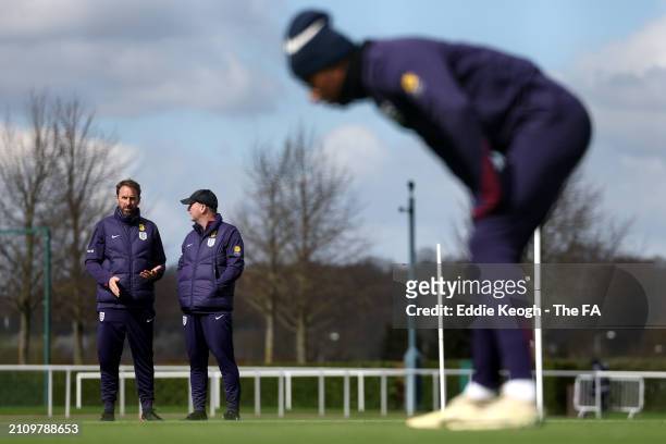 Gareth Southgate, Manager of England men's senior team, and Steve Holland, Assistant Manager of England, look on during a training session at...