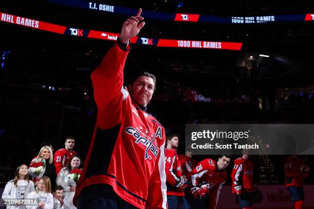 Oshie of the Washington Capitals waves to fans after being honored for playing in 1,000 career NHL games before the game against the Winnipeg Jets at...