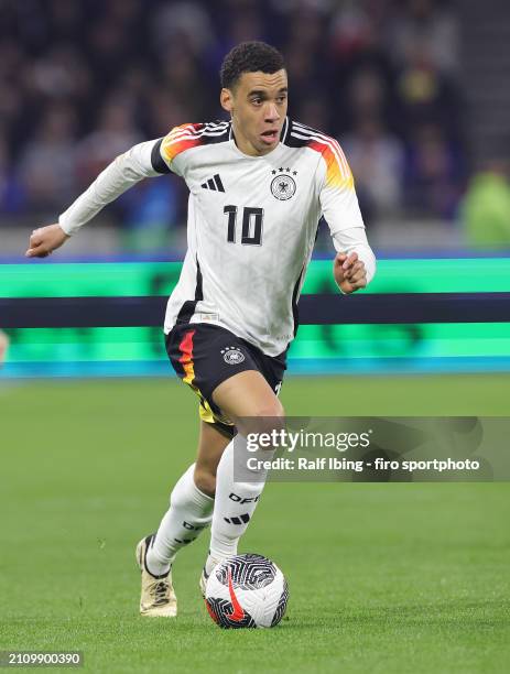 Jamal Musiala of Germany plays the ball during the international friendly match between France and Germany at Groupama Stadium on March 23, 2024 in...