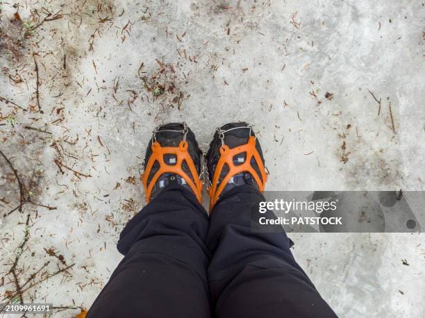 tourist wearing crampons for winter hiking in the mountains - shoe boot stock pictures, royalty-free photos & images