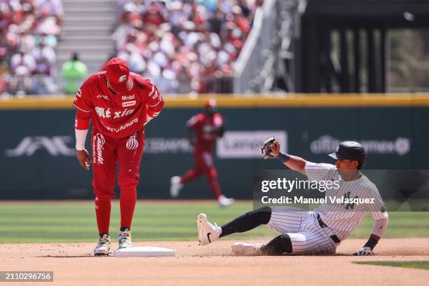 Robinson Cano of Diablos Rojos steps on second base as Oswaldo Cabrera of New York Yankees slides during the first inning of Spring Training Game One...