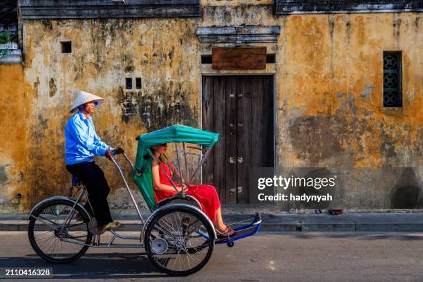 vietnamese cycle rickshaw in old town in hoi an city, vietnam - zentralvietnam stock-fotos und bilder